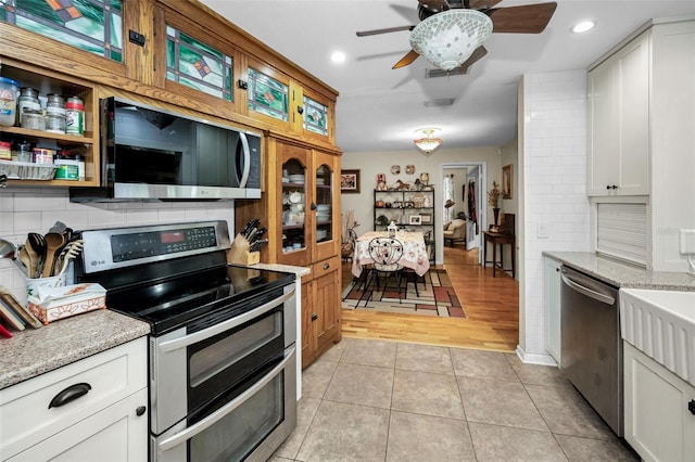1151 Lancer Ln, Tarpon Springs, FL 34689 - kitchen with stainless steel appliances, ceiling fan, light tile patterned floors, white cabinetry, and recessed lighting