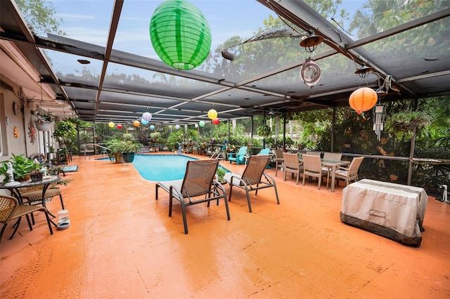 1151 Lancer Ln, Tarpon Springs, FL 34689 - swimming pool with glass enclosure, a patio area, and outdoor dining space