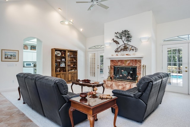 3452 Forelock Rd, Tarpon Springs, FL 34688 - living room featuring french doors, arched walkways, high vaulted ceiling, ceiling fan, and a premium fireplace