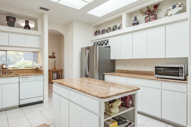 3452 Forelock Rd, Tarpon Springs, FL 34688 - kitchen featuring appliances with stainless steel finishes, open shelves, light tile patterned flooring, and a center island
