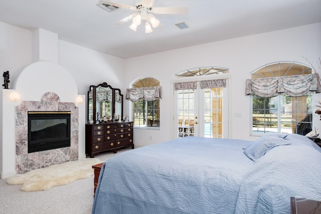 3452 Forelock Rd, Tarpon Springs, FL 34688 - carpeted bedroom featuring french doors, access to exterior, a premium fireplace, and multiple windows