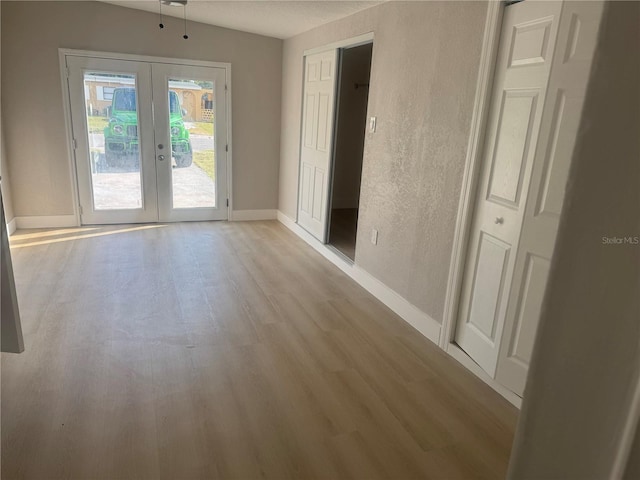 8502 Grapefruit Ave, Tampa, FL 33619 - unfurnished room with french doors, wood finished floors, baseboards, and a textured wall