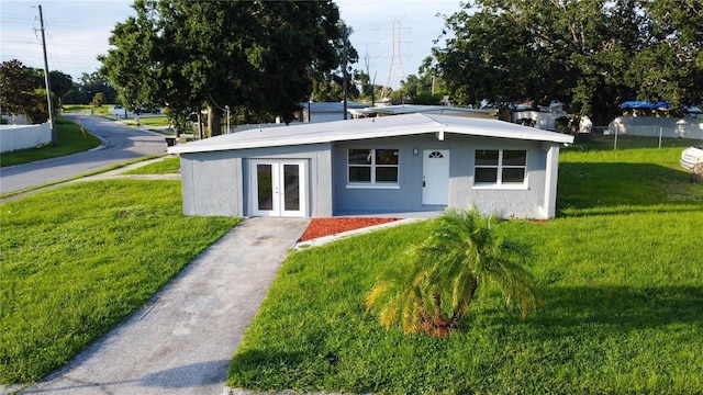 8502 Grapefruit Ave, Tampa, FL 33619 - bungalow featuring a front lawn, french doors, and stucco siding