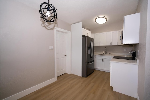 8502 Grapefruit Ave, Tampa, FL 33619 - kitchen with fridge with ice dispenser, range, stainless steel microwave, light wood-style flooring, and white cabinets