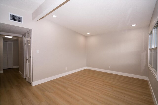 8502 Grapefruit Ave, Tampa, FL 33619 - spare room featuring light wood-style floors, recessed lighting, and beam ceiling