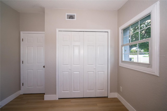 8502 Grapefruit Ave, Tampa, FL 33619 - unfurnished bedroom with wood finished floors and a closet
