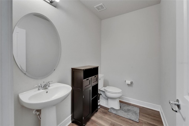 6658 Devlin Ln, Wesley Chapel, FL 33545 - bathroom with toilet, wood finished floors, and baseboards