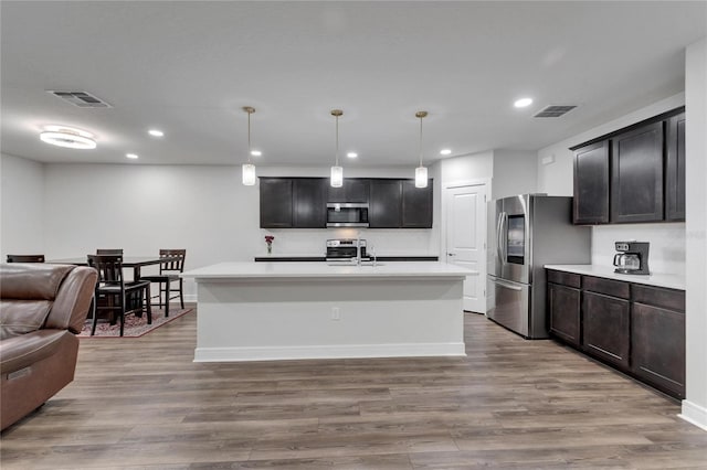 6658 Devlin Ln, Wesley Chapel, FL 33545 - kitchen with stainless steel appliances, open floor plan, light countertops, recessed lighting, and wood finished floors