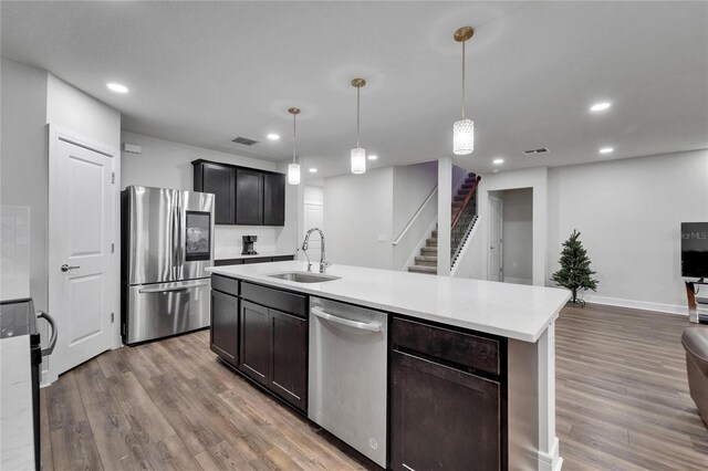 6658 Devlin Ln, Wesley Chapel, FL 33545 - kitchen featuring appliances with stainless steel finishes, a sink, wood finished floors, light countertops, and recessed lighting