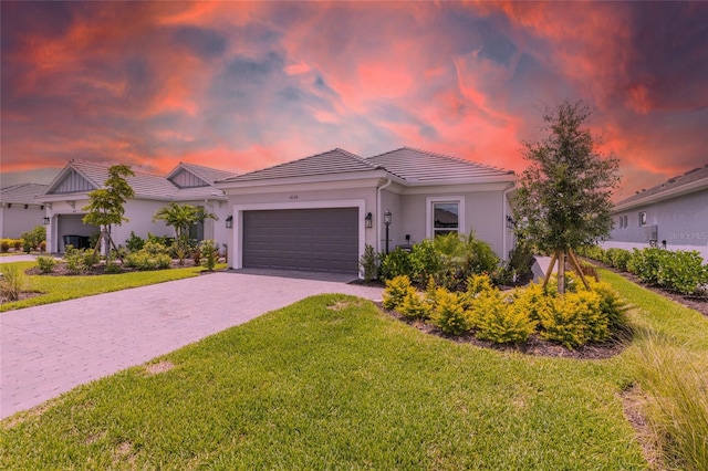16126 San Donato Pl, Bradenton, FL 34211 - view of front of home with a garage, a lawn, a tiled roof, decorative driveway, and stucco siding