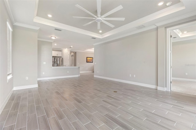 16126 San Donato Pl, Bradenton, FL 34211 - unfurnished living room with a tray ceiling, ornamental molding, a ceiling fan, recessed lighting, and light wood-style floors