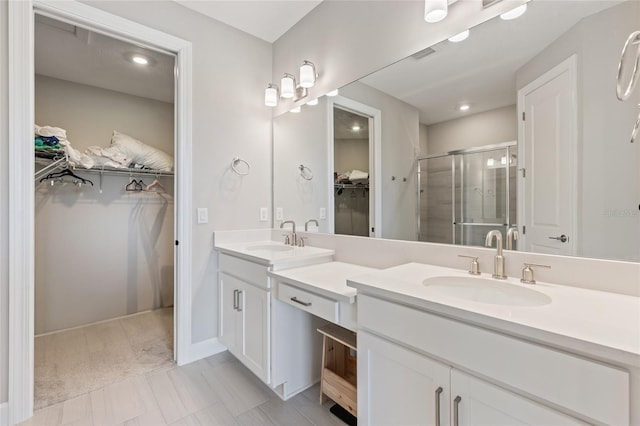 16126 San Donato Pl, Bradenton, FL 34211 - bathroom with a walk in closet, double vanity, a stall shower, and recessed lighting