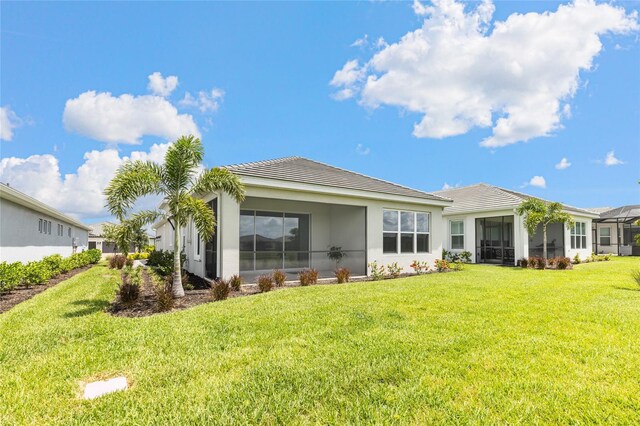 16126 San Donato Pl, Bradenton, FL 34211 - back of house with a tiled roof, a yard, a sunroom, and stucco siding