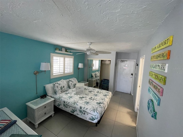 800 Bayway Blvd Unit 14, Clearwater Beach, FL 33767 - tiled bedroom with a ceiling fan, a closet, and a textured ceiling