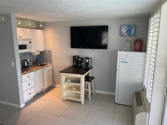 800 Bayway Blvd Unit 14, Clearwater Beach, FL 33767 - kitchen featuring white appliances, rail lighting, white cabinets, decorative backsplash, and light tile patterned floors