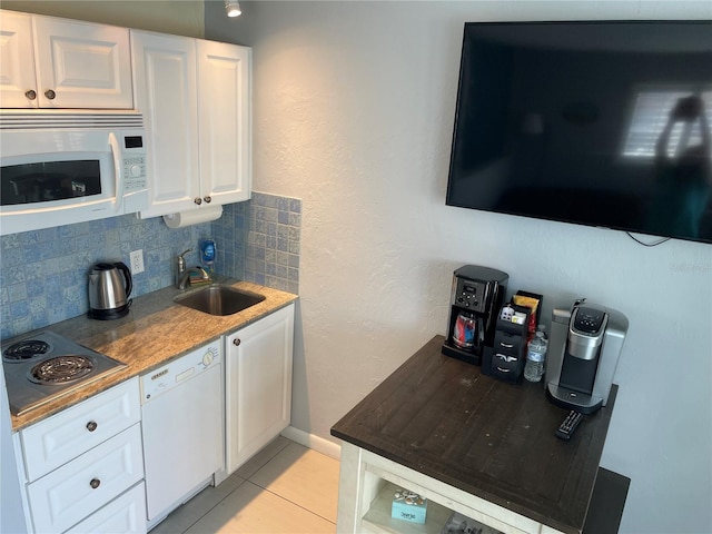 800 Bayway Blvd Unit 14, Clearwater Beach, FL 33767 - kitchen with white appliances, backsplash, white cabinetry, and light tile patterned floors