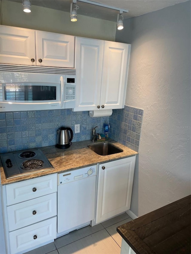 800 Bayway Blvd Unit 14, Clearwater Beach, FL 33767 - kitchen with white appliances, track lighting, decorative backsplash, white cabinetry, and a textured wall