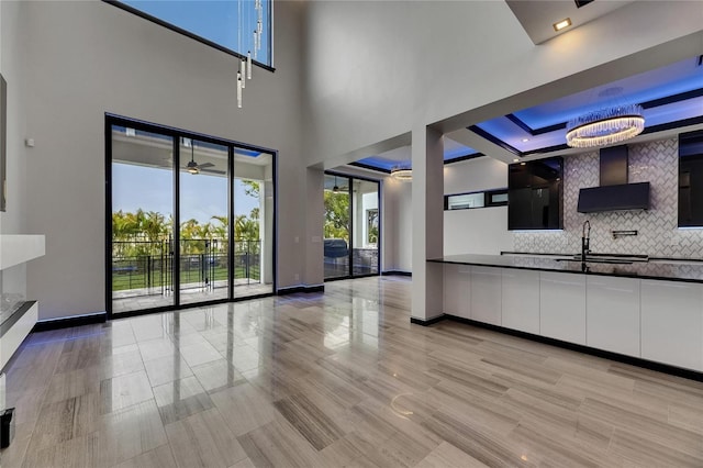 6528 Simone Shores Cir, Apollo Beach, FL 33572 - unfurnished living room featuring a sink, baseboards, ceiling fan, and a raised ceiling