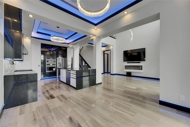 6528 Simone Shores Cir, Apollo Beach, FL 33572 - kitchen with a raised ceiling, a sink, appliances with stainless steel finishes, modern cabinets, and range hood