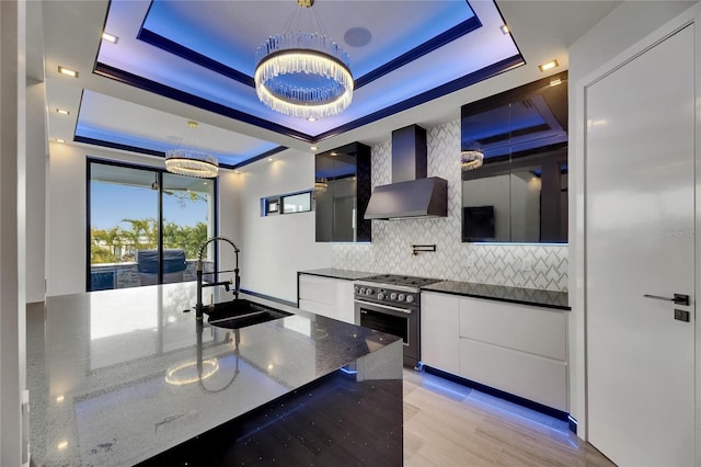 6528 Simone Shores Cir, Apollo Beach, FL 33572 - kitchen with a sink, high end stainless steel range oven, a tray ceiling, modern cabinets, and wall chimney range hood