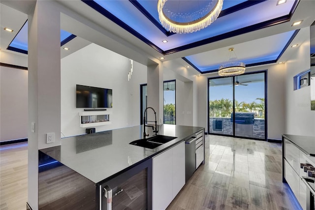 6528 Simone Shores Cir, Apollo Beach, FL 33572 - kitchen featuring a sink, a raised ceiling, beverage cooler, modern cabinets, and white cabinets