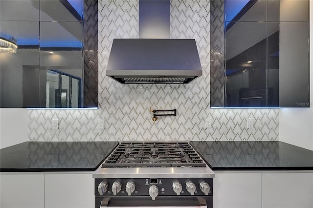 6528 Simone Shores Cir, Apollo Beach, FL 33572 - kitchen with dark countertops, wall chimney range hood, stainless steel gas range, and decorative backsplash