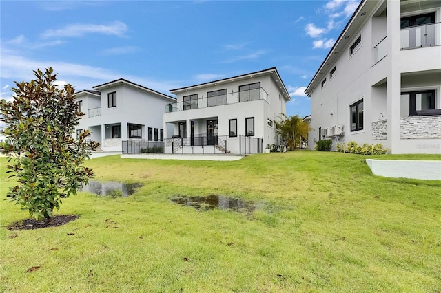 6528 Simone Shores Cir, Apollo Beach, FL 33572 - back of house with stucco siding, a yard, and a balcony