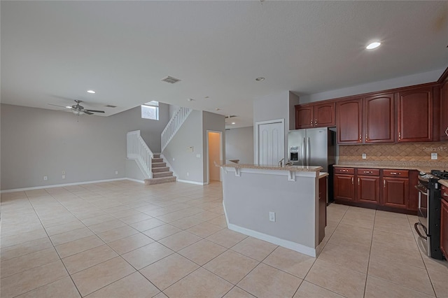 20109 Bay Cedar Ave, Tampa, FL 33647 - kitchen with range with gas cooktop, light tile patterned floors, tasteful backsplash, stainless steel fridge with ice dispenser, and recessed lighting