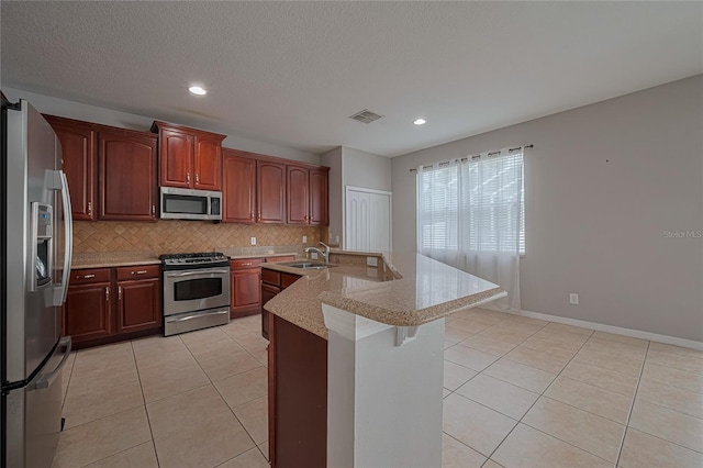 20109 Bay Cedar Ave, Tampa, FL 33647 - kitchen featuring stainless steel appliances, a sink, light tile patterned flooring, decorative backsplash, and recessed lighting