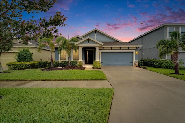 6127 Colmar Pl, Apollo Beach, FL 33572 - view of front of house featuring an attached garage, driveway, a lawn, and stucco siding
