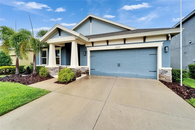 6127 Colmar Pl, Apollo Beach, FL 33572 - view of front of property with stone siding, driveway, a garage, and stucco siding