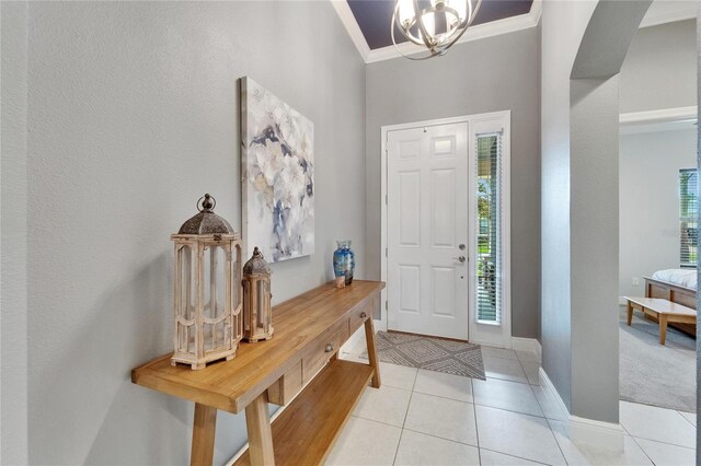 6127 Colmar Pl, Apollo Beach, FL 33572 - entryway with ornamental molding, light tile patterned floors, baseboards, a chandelier, and arched walkways
