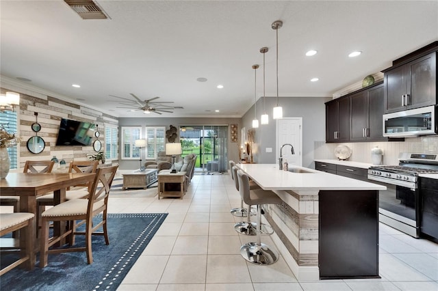 6127 Colmar Pl, Apollo Beach, FL 33572 - kitchen with appliances with stainless steel finishes, a sink, crown molding, open floor plan, and recessed lighting