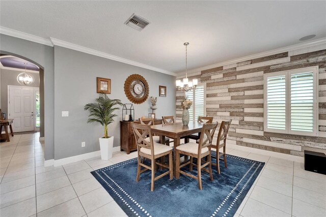 6127 Colmar Pl, Apollo Beach, FL 33572 - dining room featuring arched walkways, a chandelier, light tile patterned floors, crown molding, and baseboards
