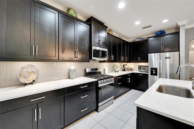 6127 Colmar Pl, Apollo Beach, FL 33572 - kitchen featuring appliances with stainless steel finishes, a sink, light countertops, light tile patterned flooring, and decorative backsplash