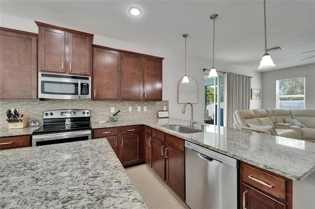449 Bahama Grande Blvd, Apollo Beach, FL 33572 - kitchen with stainless steel appliances, a sink, open floor plan, decorative backsplash, and a peninsula