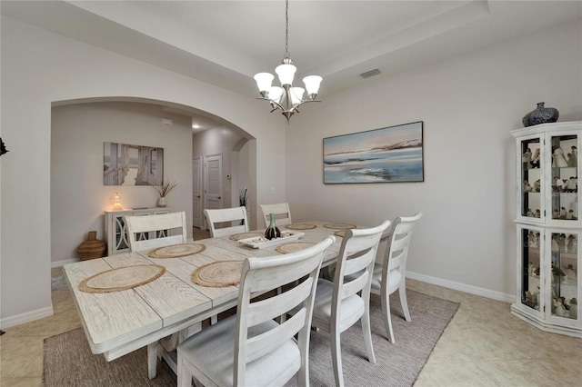 449 Bahama Grande Blvd, Apollo Beach, FL 33572 - dining area featuring arched walkways, a chandelier, a raised ceiling, and light tile patterned flooring