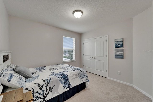 449 Bahama Grande Blvd, Apollo Beach, FL 33572 - bedroom featuring light carpet, a closet, baseboards, and a textured ceiling