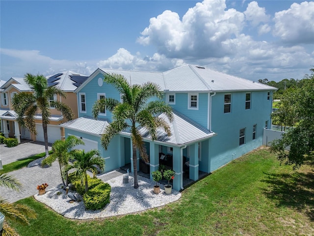 449 Bahama Grande Blvd, Apollo Beach, FL 33572 - back of property featuring a lawn, decorative driveway, metal roof, and stucco siding