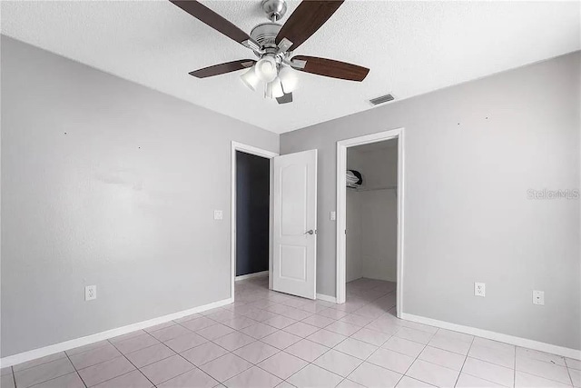13377 Elise Ln, Spring Hill, FL 34609 - unfurnished bedroom with a closet, baseboards, a textured ceiling, a ceiling fan, and light tile patterned floors