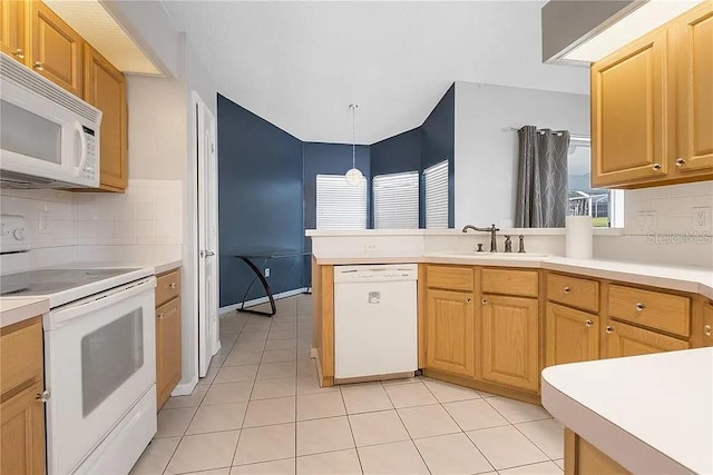 13377 Elise Ln, Spring Hill, FL 34609 - kitchen with white appliances, a peninsula, decorative backsplash, light countertops, and a sink