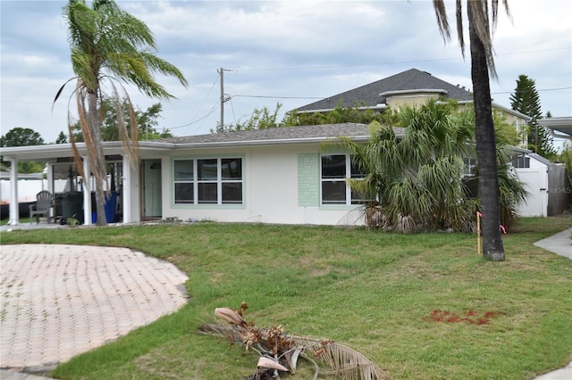 2470 Del Rio Way, Dunedin, FL 34698 - view of front of property featuring a front yard, stucco siding, and roof with shingles