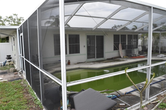 2470 Del Rio Way, Dunedin, FL 34698 - back of property with glass enclosure, an outdoor pool, and a patio