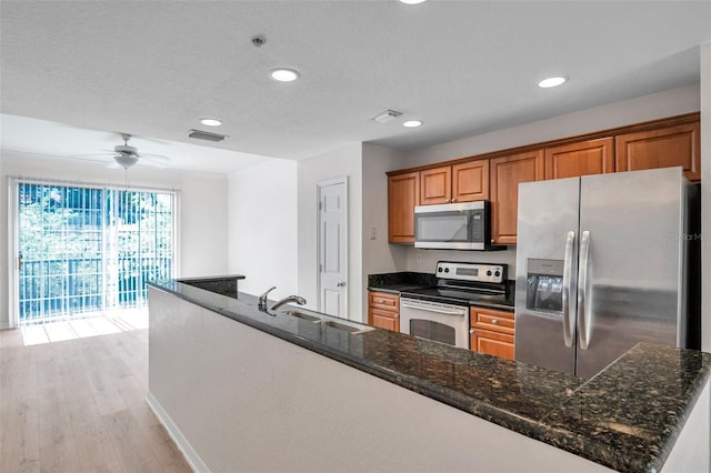 113 S Sherrill St Unit 113, Tampa, FL 33609 - kitchen featuring appliances with stainless steel finishes, a sink, recessed lighting, brown cabinets, and light wood-style floors