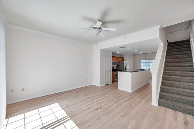 113 S Sherrill St Unit 113, Tampa, FL 33609 - unfurnished living room featuring ceiling fan, stairway, light wood-style floors, crown molding, and baseboards