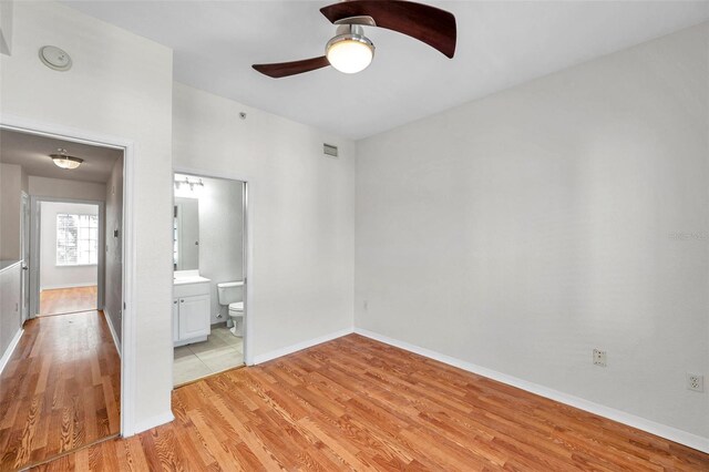 113 S Sherrill St Unit 113, Tampa, FL 33609 - unfurnished bedroom with light wood finished floors, baseboards, a ceiling fan, and connected bathroom
