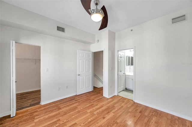 113 S Sherrill St Unit 113, Tampa, FL 33609 - unfurnished bedroom featuring light wood-style flooring, a closet, a walk in closet, and baseboards