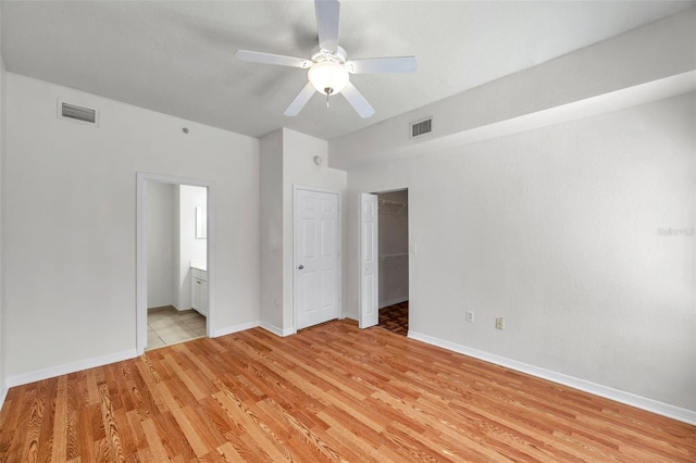 113 S Sherrill St Unit 113, Tampa, FL 33609 - unfurnished bedroom featuring light wood-type flooring, baseboards, ensuite bathroom, and ceiling fan