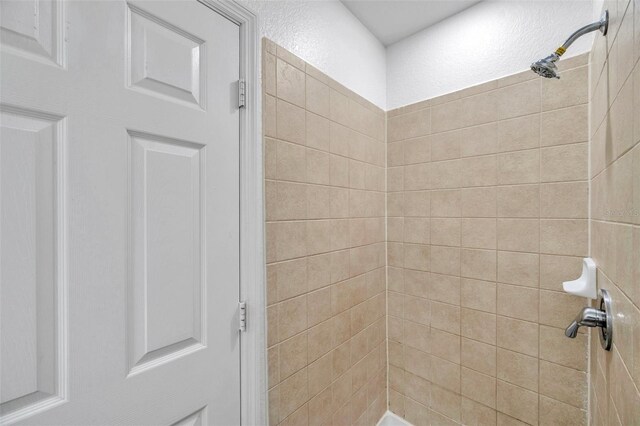 113 S Sherrill St Unit 113, Tampa, FL 33609 - bathroom featuring a tile shower and a textured wall