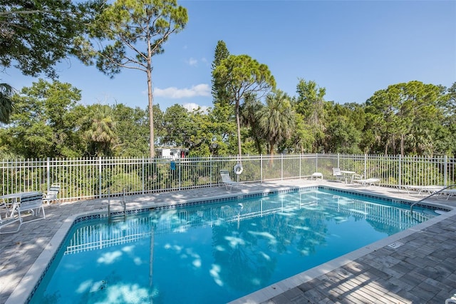 13521 Forest Lake Dr, Largo, FL 33771 - community pool with a patio area and view of scattered trees